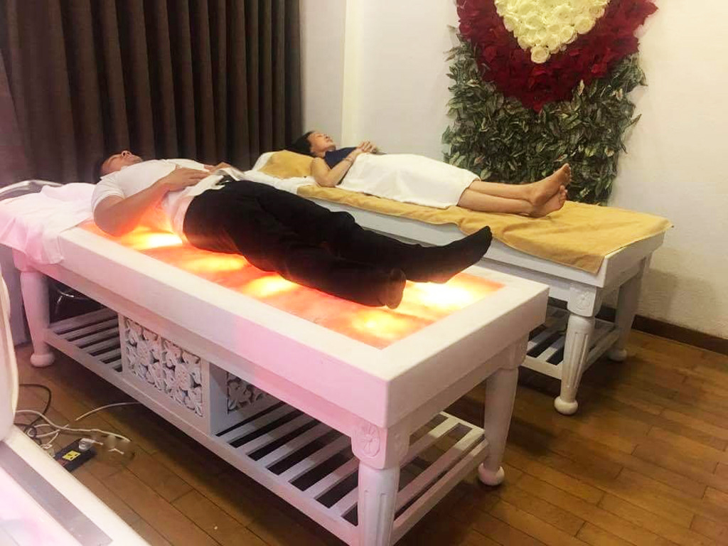 Khách hàng thư giãn cùng sản phẩm giường đá muối Himalaya Khách hàng thư giãn cùng sản phẩm giường đá muối Himalaya